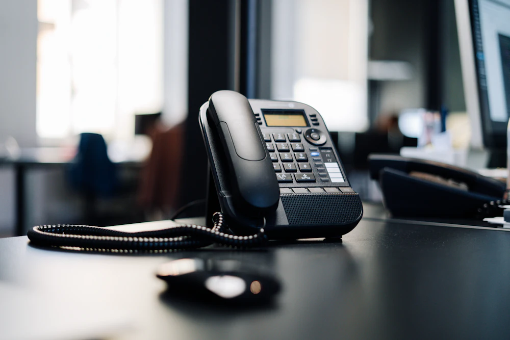 Teléfono de oficina sobre una mesa de trabajo